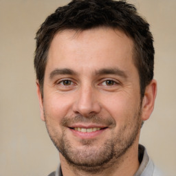 Joyful white adult male with short  brown hair and brown eyes