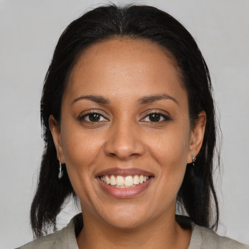 Joyful latino young-adult female with medium  brown hair and brown eyes