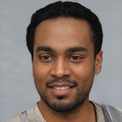 Joyful black young-adult male with short  black hair and brown eyes