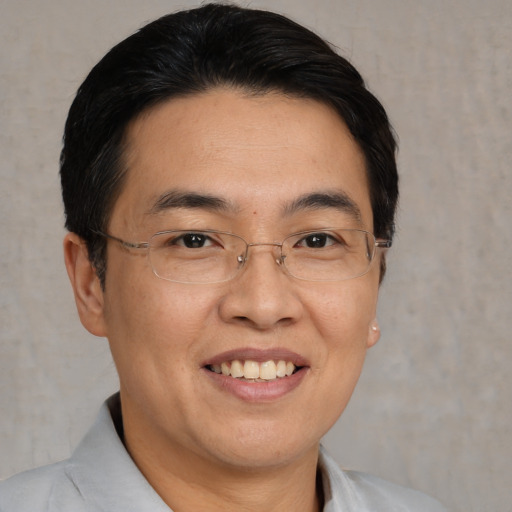 Joyful asian adult male with short  brown hair and brown eyes