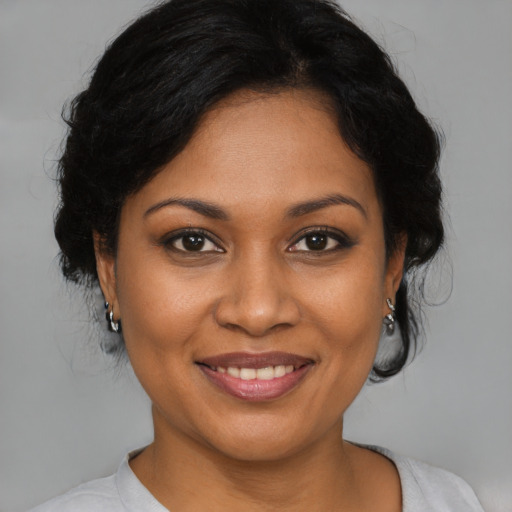 Joyful black young-adult female with medium  brown hair and brown eyes