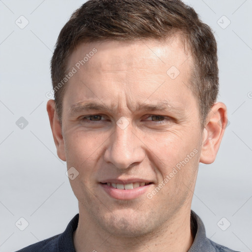 Joyful white adult male with short  brown hair and grey eyes