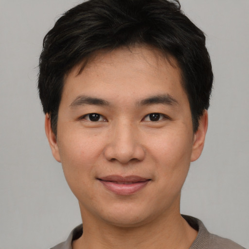 Joyful asian young-adult male with short  black hair and brown eyes