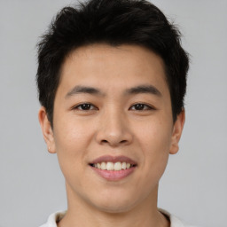 Joyful asian young-adult male with short  brown hair and brown eyes