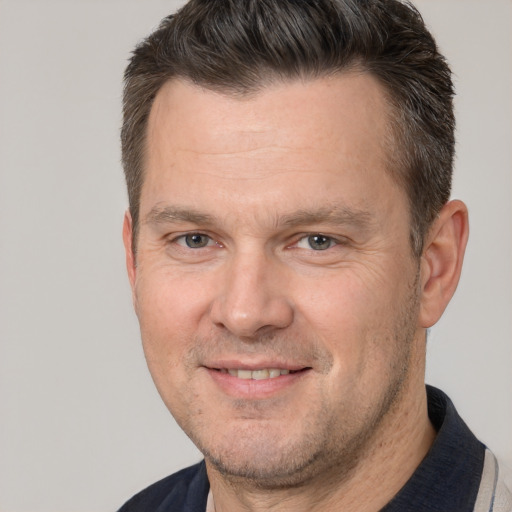 Joyful white adult male with short  brown hair and brown eyes