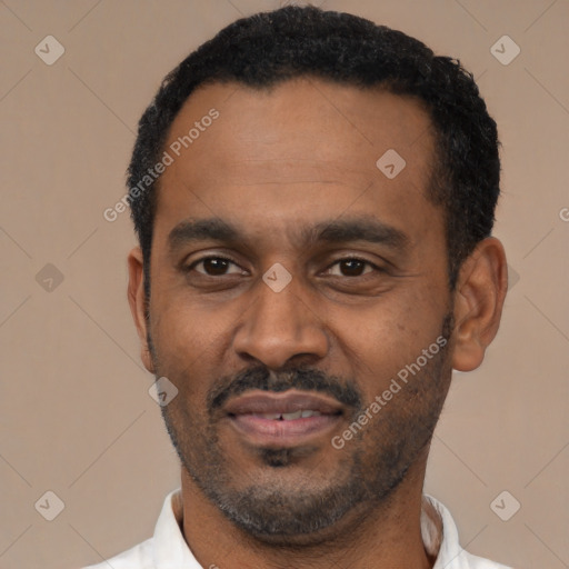 Joyful black adult male with short  black hair and brown eyes