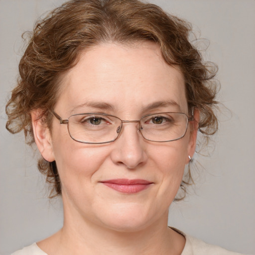 Joyful white adult female with medium  brown hair and blue eyes