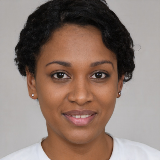Joyful black young-adult female with short  black hair and brown eyes