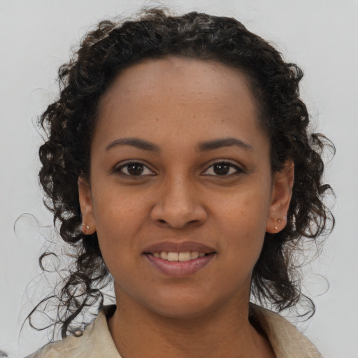 Joyful black young-adult female with long  black hair and brown eyes