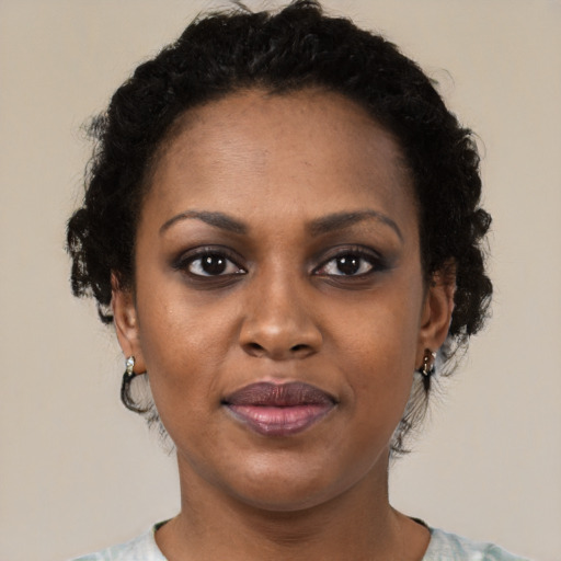 Joyful black adult female with short  brown hair and brown eyes