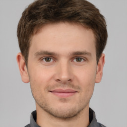 Joyful white young-adult male with short  brown hair and grey eyes