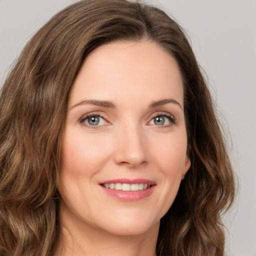 Joyful white young-adult female with long  brown hair and green eyes