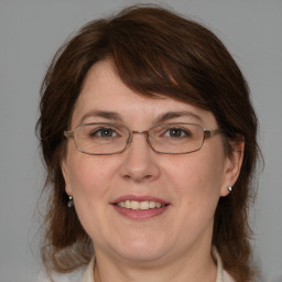 Joyful white adult female with medium  brown hair and blue eyes