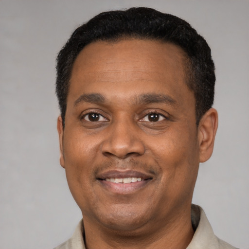 Joyful latino adult male with short  black hair and brown eyes