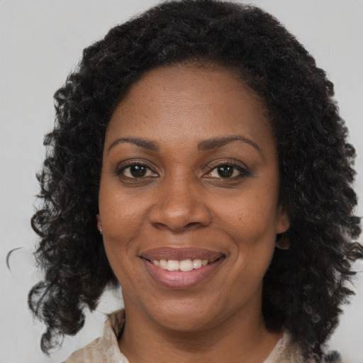 Joyful black adult female with medium  brown hair and brown eyes