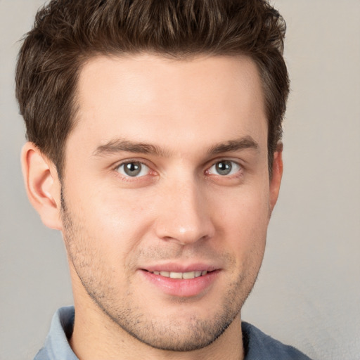 Joyful white young-adult male with short  brown hair and grey eyes