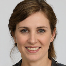 Joyful white young-adult female with medium  brown hair and grey eyes