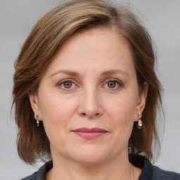 Joyful white adult female with medium  brown hair and grey eyes