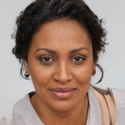 Joyful black adult female with short  brown hair and brown eyes