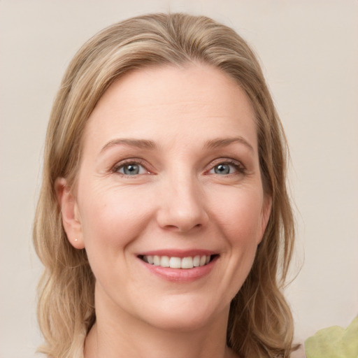 Joyful white young-adult female with medium  brown hair and green eyes