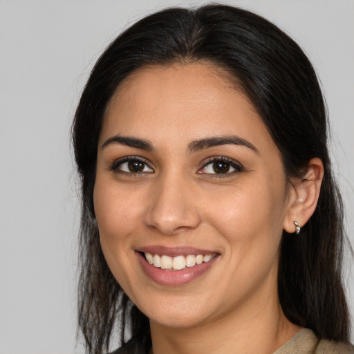 Joyful latino young-adult female with long  brown hair and brown eyes