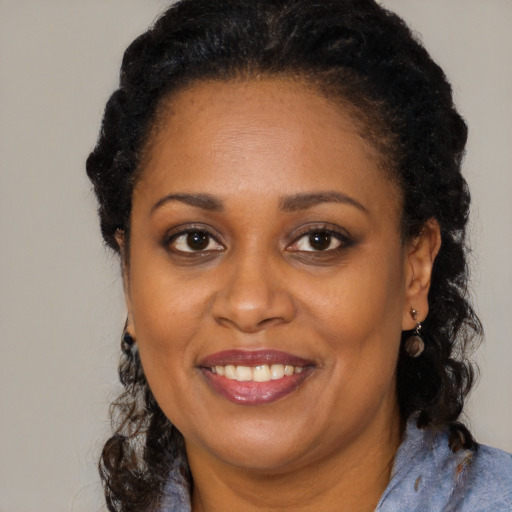Joyful black adult female with medium  brown hair and brown eyes
