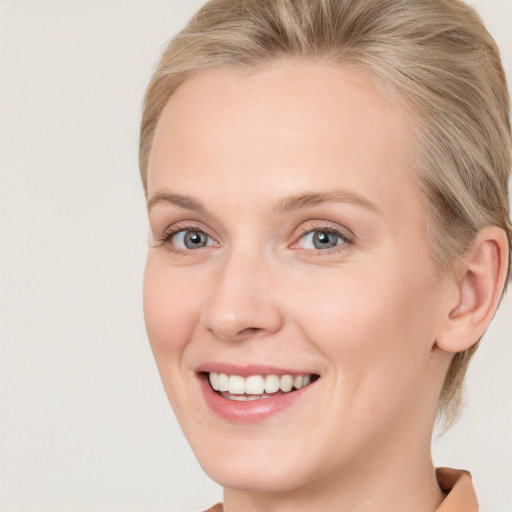 Joyful white young-adult female with medium  brown hair and blue eyes