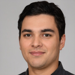 Joyful white young-adult male with short  black hair and brown eyes