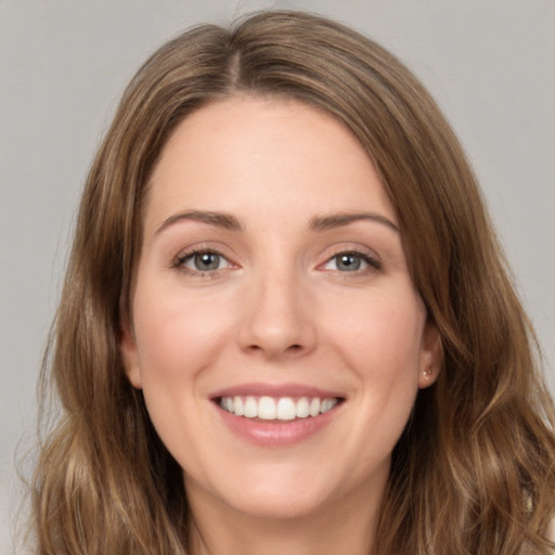 Joyful white young-adult female with long  brown hair and green eyes