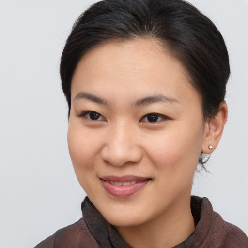 Joyful asian young-adult female with medium  brown hair and brown eyes