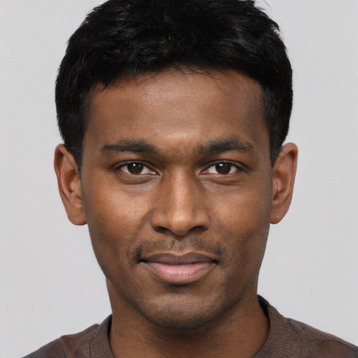 Joyful black young-adult male with short  black hair and brown eyes