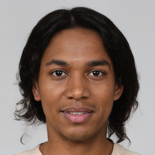 Joyful black young-adult male with medium  black hair and brown eyes