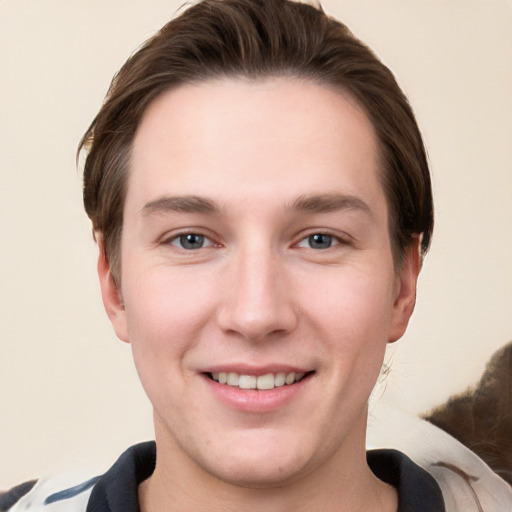 Joyful white young-adult male with short  brown hair and grey eyes