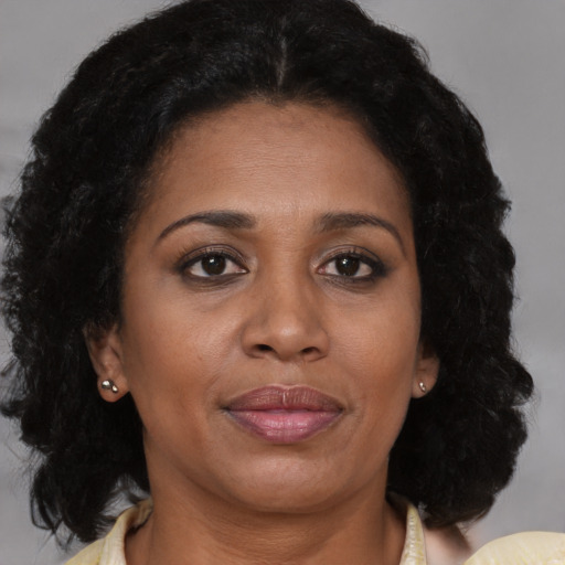 Joyful black adult female with medium  brown hair and brown eyes