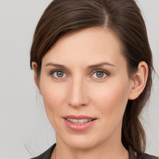 Joyful white young-adult female with long  brown hair and brown eyes