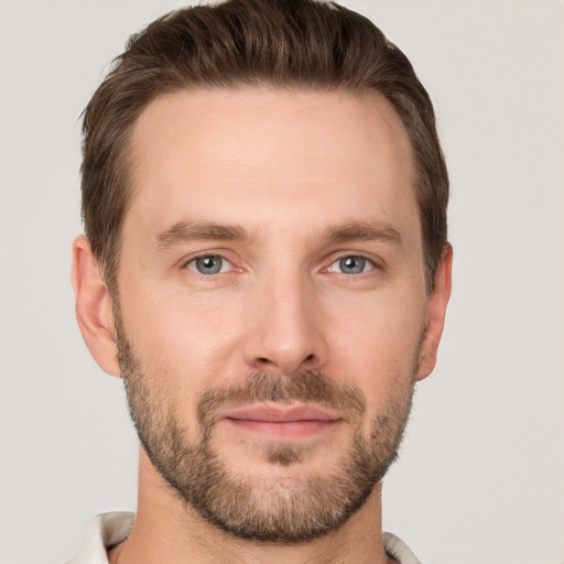 Joyful white young-adult male with short  brown hair and grey eyes