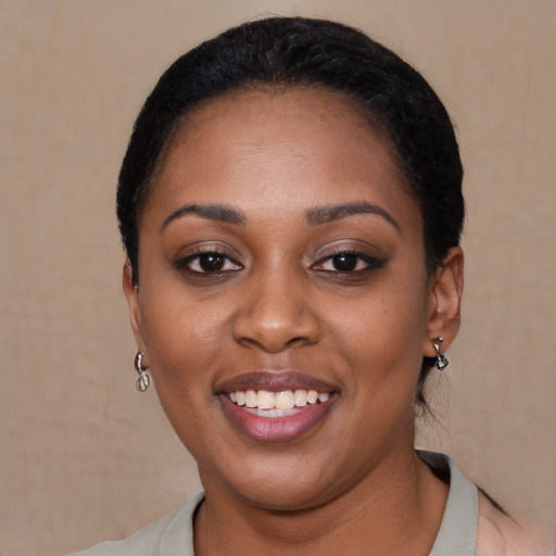 Joyful black young-adult female with short  black hair and brown eyes