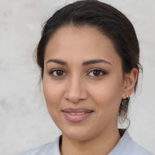 Joyful latino young-adult female with medium  brown hair and brown eyes