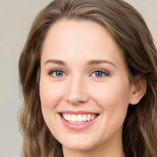 Joyful white young-adult female with long  brown hair and green eyes