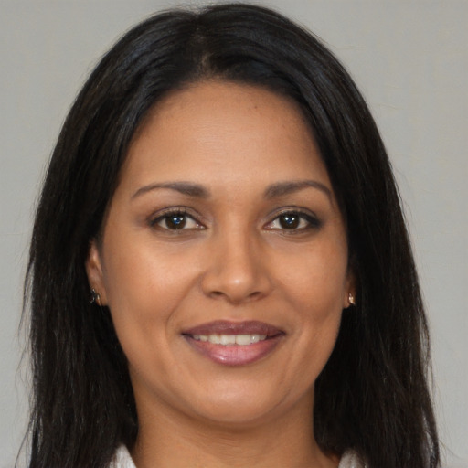 Joyful latino young-adult female with long  brown hair and brown eyes