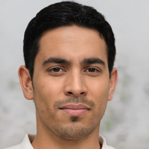 Joyful latino young-adult male with short  black hair and brown eyes