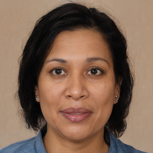 Joyful latino adult female with medium  brown hair and brown eyes