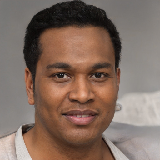 Joyful latino young-adult male with short  brown hair and brown eyes