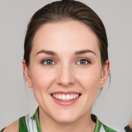 Joyful white young-adult female with medium  brown hair and green eyes