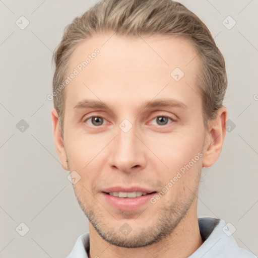 Joyful white young-adult male with short  brown hair and grey eyes