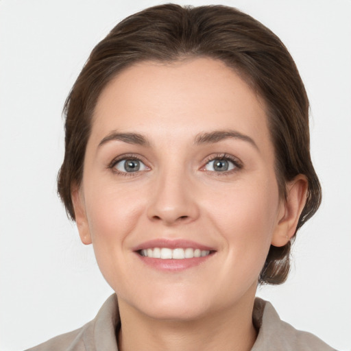 Joyful white young-adult female with medium  brown hair and grey eyes