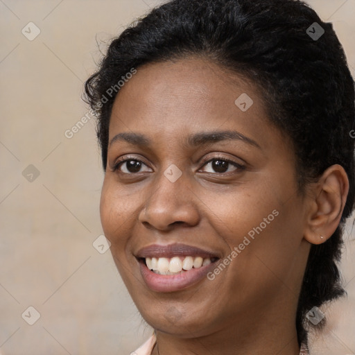 Joyful black young-adult female with short  black hair and brown eyes