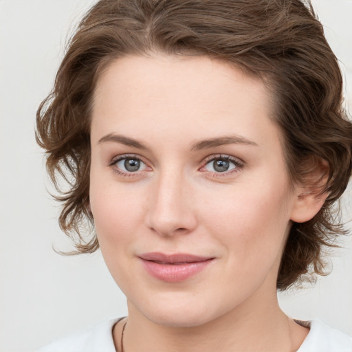 Joyful white young-adult female with medium  brown hair and green eyes