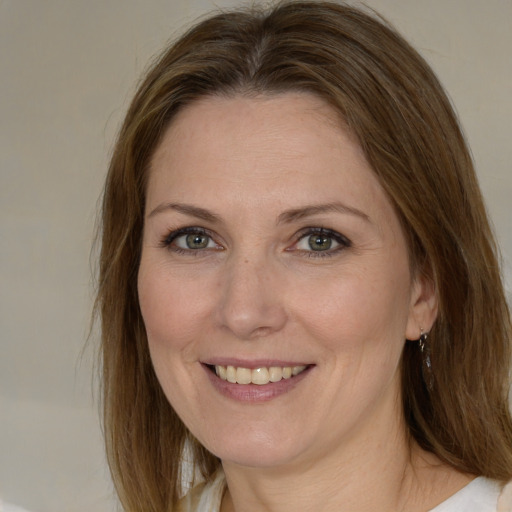 Joyful white young-adult female with medium  brown hair and green eyes