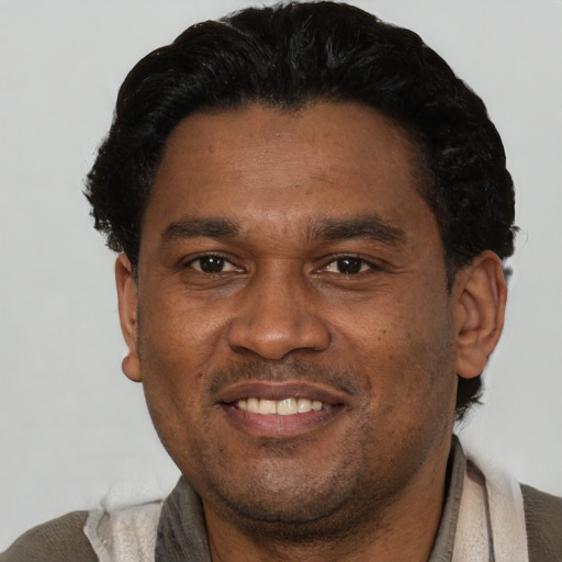 Joyful latino adult male with short  black hair and brown eyes